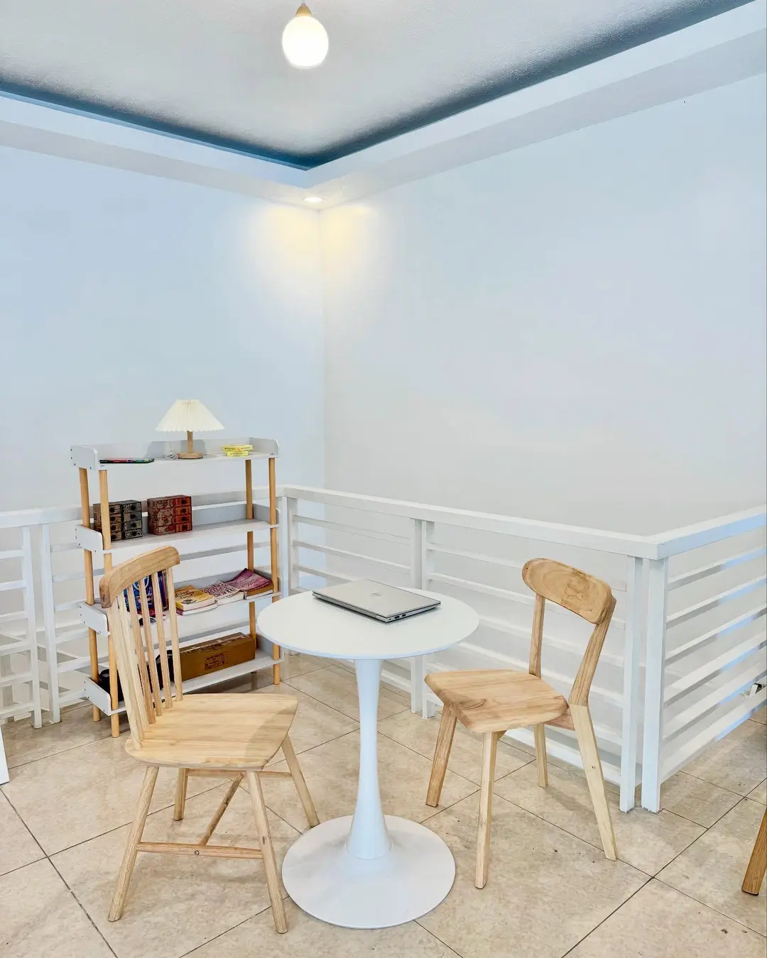 Reading corner with a stocked bookshelf and a small white table