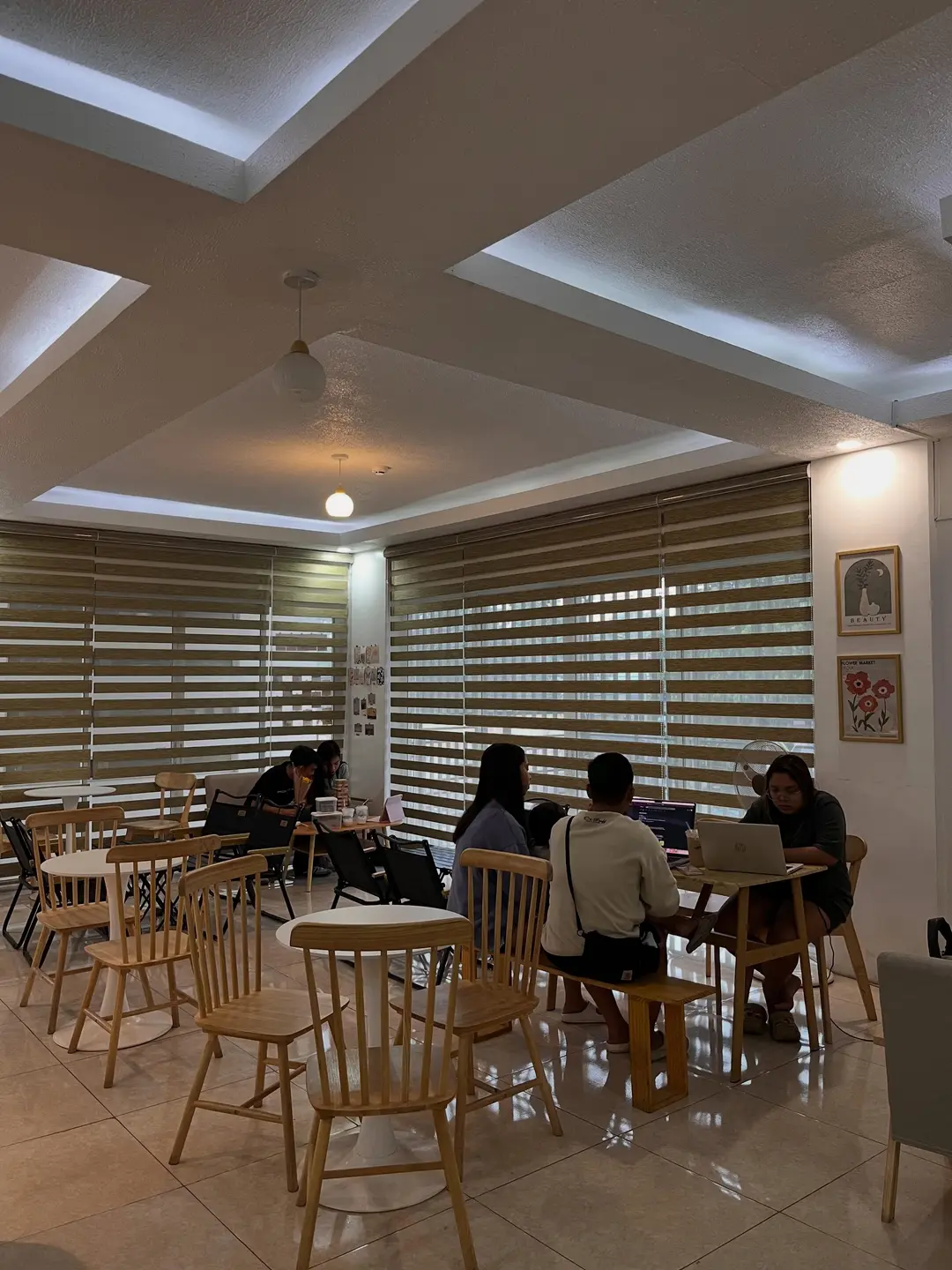 Students studying together at café tables in the afternoon