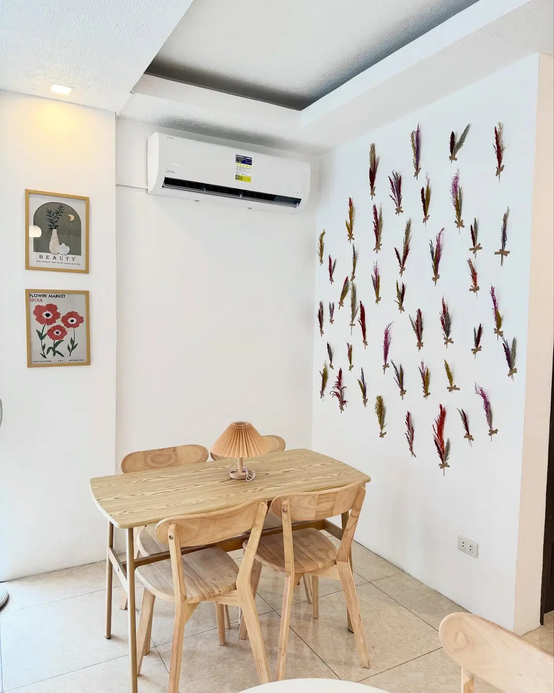Café tables under warm lamps beside the window blinds