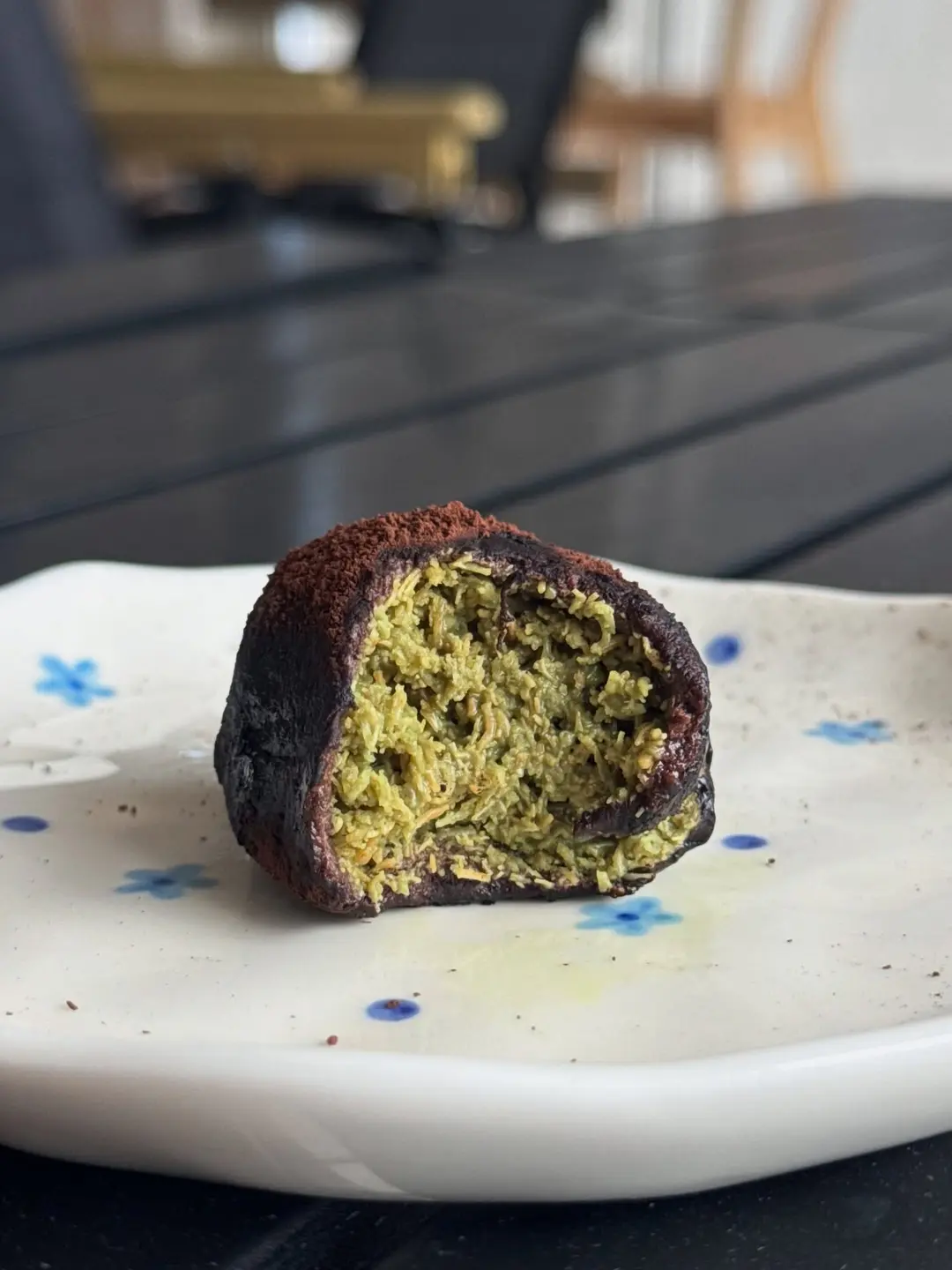 A bitten matcha truffle showing its green center