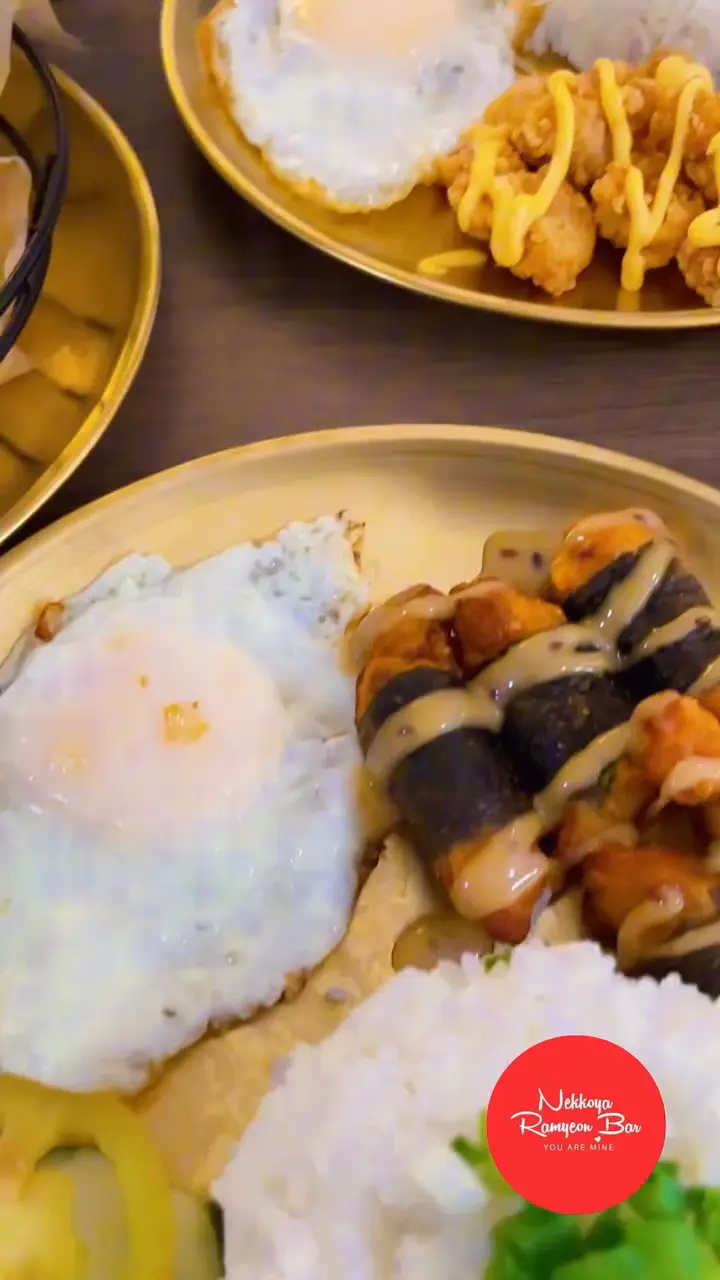 Fried egg, rice and chicken karaage plates on gold trays