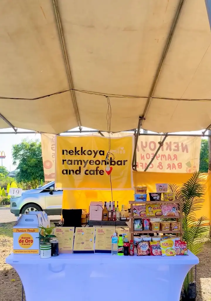 The Nekkoya pop-up stall under a tent with its branded table and products